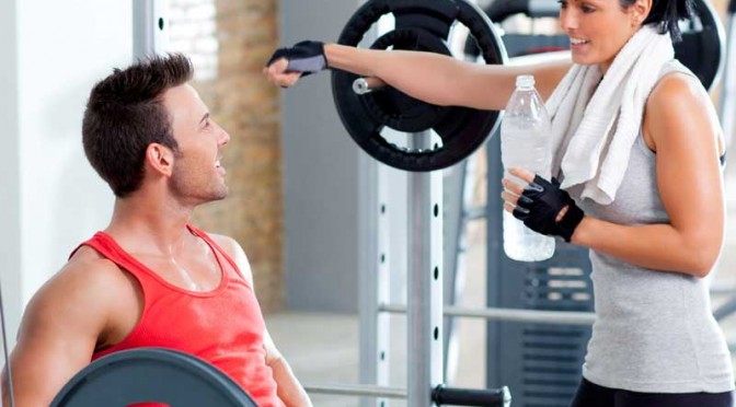 Girl Flirts with Guy next to Weight Rack