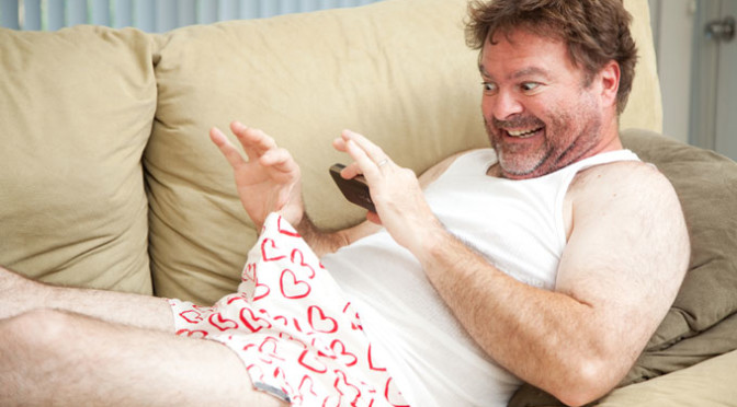 Middle aged man sexting from couch